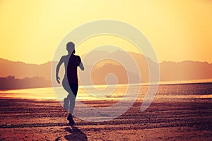 Healthy lifestyle woman running at sunrise beach