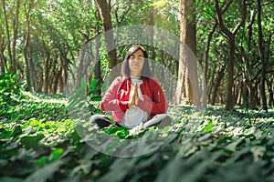 Healthy lifestyle for women practicing meditation and yoga in the forest. Young woman practicing yoga outdoors. Meditation concept