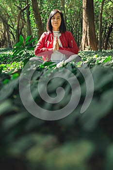 Healthy lifestyle for women practicing meditation and yoga in the forest. Young woman practicing yoga outdoors. Meditation concept