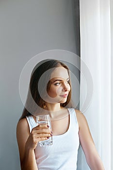 Healthy lifestyle.Young woman drinking from a glass of fresh water. Healthcare. Drinks.