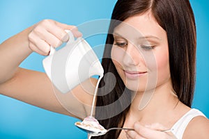 Healthy lifestyle - young woman pour milk cereal