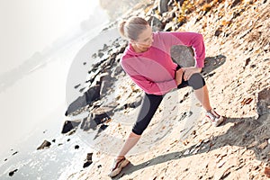 Healthy Lifestyle. Young woman warming up near lake autumn season right lunge smiling joyful