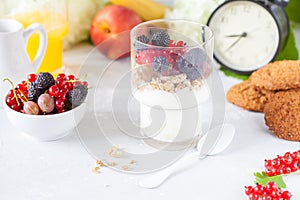 Healthy light breakfast: parfait with berries and yogurt, orange