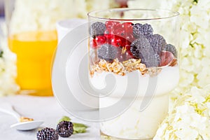 Healthy light breakfast: parfait with berries and yogurt, orange