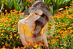 Healthy Long Curly Hair. Beautiful Brunette Woman over marigold