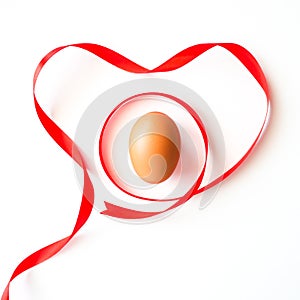 Healthy love food valentine day idea concept, Isolated gift of fresh chicken egg with red heart symbol ribbon on white background