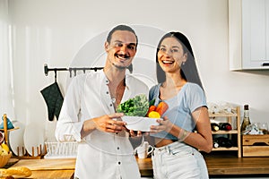 Healthy lovers cooking food in kitchen, Happy young couple spending time together at home, Husband and wife relaxing and