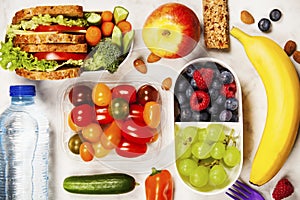 Healthy lunch box with sandwich and fresh vegetables, bottle of