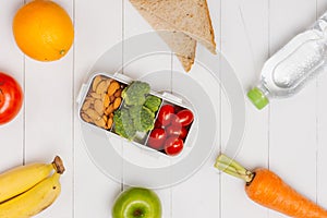 Healthy lunch box with sandwich and fresh vegetables, bottle of