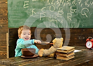 Healthy lunch in school cafeteria. Little child share healthy lunch with toy friend. Boy enjoy healthy lunch with teddy