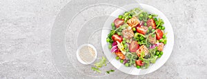 Healthy lunch vegetable salad with baked salmon fish, fresh green peas, lettuce and tomato. Banner