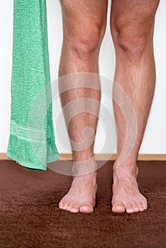 Healthy male feet with towel stepping towards