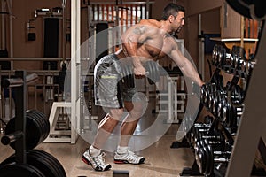 Healthy Man Doing Exercise For Back With Dumbbells