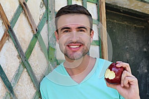 Healthy man eating an apple joyfully