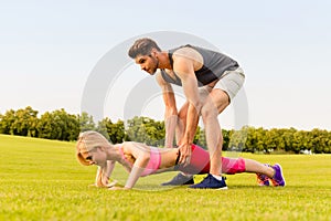 Healthy man helping his girlfriend doing push-up