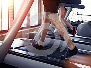 Healthy man and woman running on a treadmill