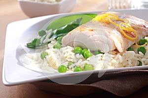 Healthy meal of baked fish, rice and peas