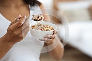 Healthy Meal Concept. Unrecognizable black woman eating oatmeal with fruits for breakfast