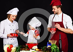 Healthy meal and dinner preparation. Happy family preparing breakfast together. Parents teaching little boy to cook