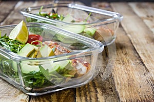 Healthy meal prep containers with rukola, turkey grill, tomatoes and avocado