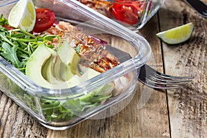 Healthy meal prep containers with rukola, turkey grill, tomatoes and avocado