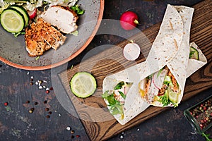 Healthy mexican tacos with baked chicken breast, cucumber, radish and lettuce.