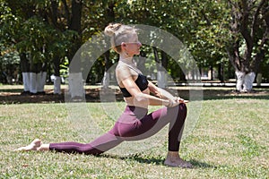 Healthy middle aged woman doing fitness stretching outdoors