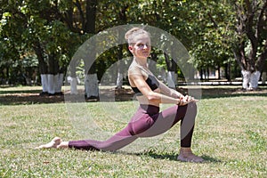 Healthy middle aged woman doing fitness stretching outdoors