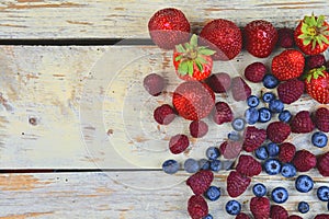 Healthy mixed fruit and ingredients with strawberry, raspberry, blueberry from top view. Berries on rustic white wooden