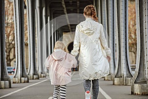 Healthy mother and child on Pont de Bir-Hakeim bridge walking