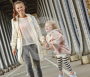 Healthy mother and child on Pont de Bir-Hakeim bridge walking