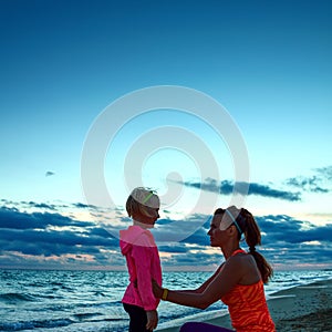 Healthy mother and child on seashore on sunset