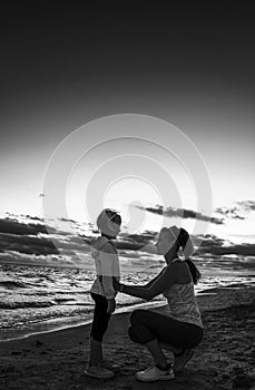 Healthy mother and child on seashore on sunset