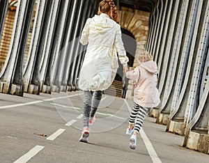 Healthy mother and daughter on Pont de Bir-Hakeim bridge walking