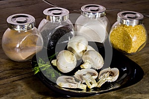 Healthy mushrooms champignons on a black plate