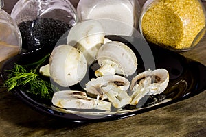 Healthy mushrooms champignons on a black plate