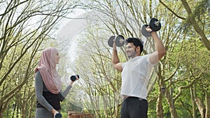 Healthy muslim couple in sportswear having outdoors workout during morning time. Young man and woman training muscles