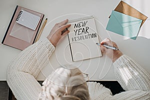 Healthy New Years resolutions for older adults. Senior mature old woman in white sweater writing handwritten text New