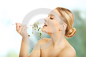 Healthy nude woman eating cuckooflower