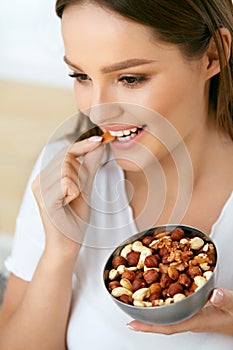 Healthy Nutrition. Beautiful Young Woman Eating Nuts