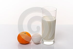 Healthy nutrition. Fresh mandarin, organic egg and a glass of milk isolated on white background