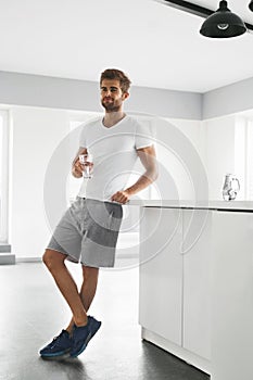 Healthy Nutrition. Man Drinking Glass Of Fresh Water In Morning