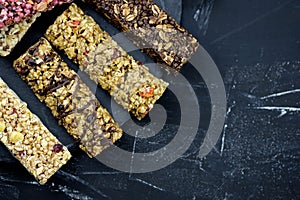 Healthy nutritious snacks. fitness bars on black background top view