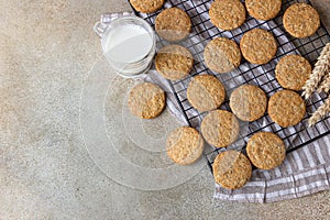 Healthy oatmeal cookies with cereals, seeds and nuts with a cup of milk on concrete background. Diet vegan cookies. Top view