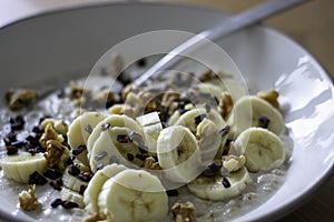 Healthy oatmeal porridge with banana, walnuts and cacao nibs