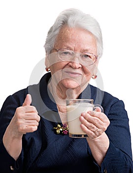 Healthy old woman holding a glass milk