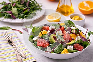 Healthy orange, avocado, grapefruit and pomegranate salad with honey and mustard dressing.