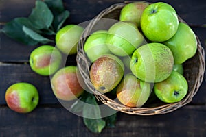 Healthy organic apples in a basket on a wooden background. Autumn harvest.