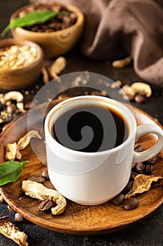 Healthy organic energizing adaptogen. Mushroom coffee in a cup and coffee beans, trendy drink on a stone background