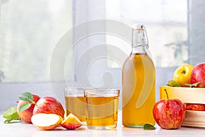 Healthy organic food. Apple cider vinegar or juice in glass bottle and fresh red apples.